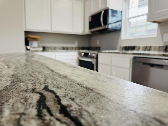 207 W Military Rd, North Little Rock, AR 72118 - kitchen with appliances with stainless steel finishes, white cabinets, and light stone counters