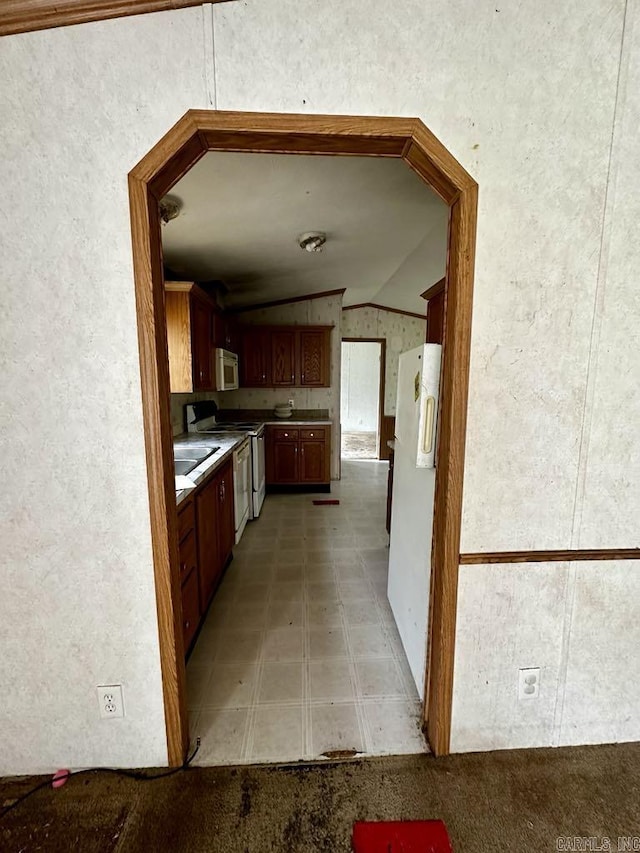 4530 Hwy 8 E, Mena, AR 71953 - kitchen with lofted ceiling, range with electric cooktop, freestanding refrigerator, and a sink