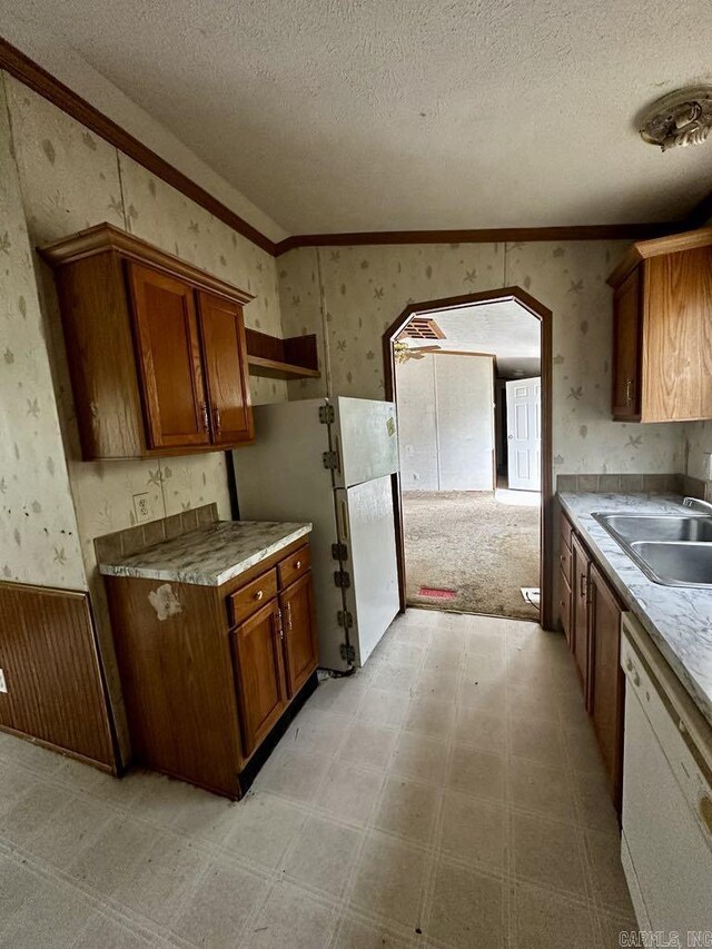 4530 Hwy 8 E, Mena, AR 71953 - kitchen with white appliances, a sink, wallpapered walls, brown cabinets, and arched walkways