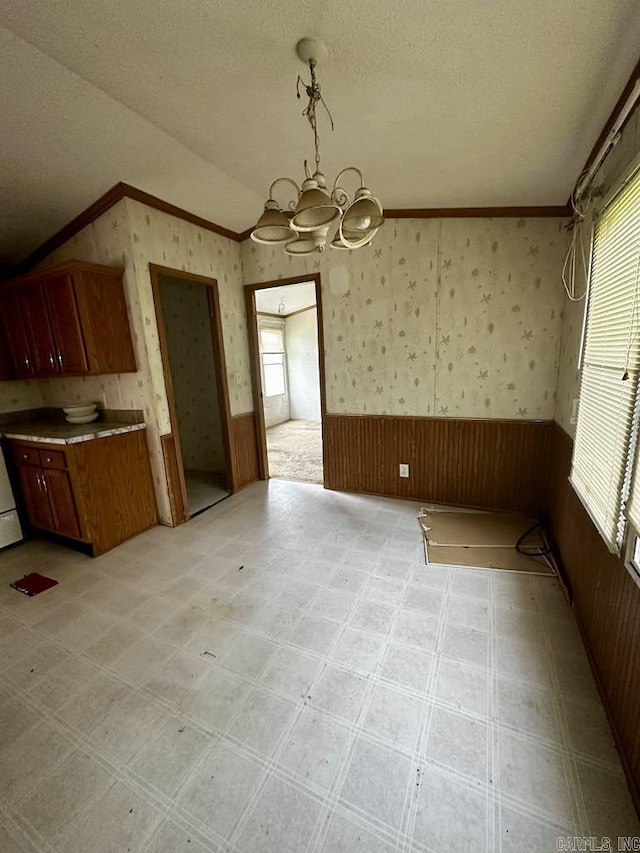 4530 Hwy 8 E, Mena, AR 71953 - unfurnished dining area featuring wainscoting, a chandelier, lofted ceiling, ornamental molding, and wallpapered walls