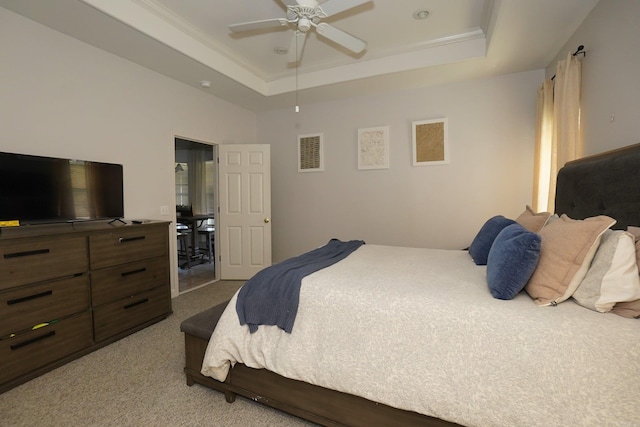 bedroom with carpet flooring, a raised ceiling, and a ceiling fan