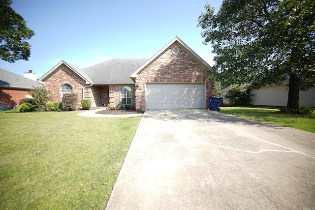 view of front of home with a garage, driveway, a front lawn, brick siding, and roof with shingles