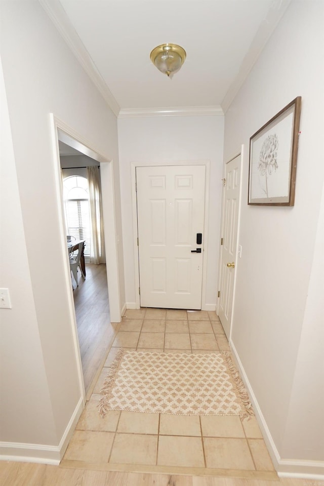 hall featuring ornamental molding, light tile patterned floors, and baseboards