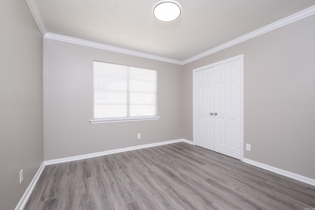 202 Gilbert Dr, Little Rock, AR 72205 - unfurnished bedroom with wood finished floors, crown molding, a closet, and baseboards