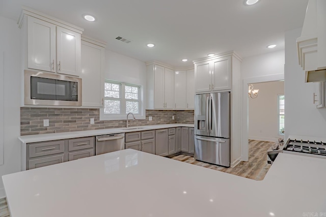 1500 S Church St, Jonesboro, AR 72401 - kitchen with appliances with stainless steel finishes, a sink, backsplash, light wood-style floors, and light countertops