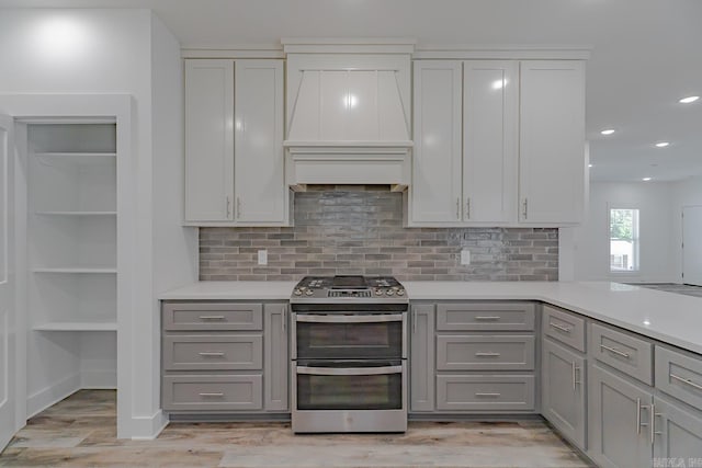 1500 S Church St, Jonesboro, AR 72401 - kitchen with double oven range, gray cabinetry, premium range hood, light countertops, and tasteful backsplash