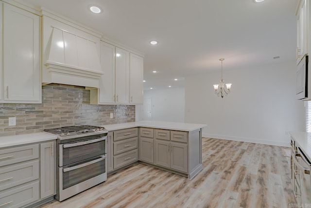 1500 S Church St, Jonesboro, AR 72401 - kitchen with double oven range, gray cabinetry, a chandelier, tasteful backsplash, and light countertops