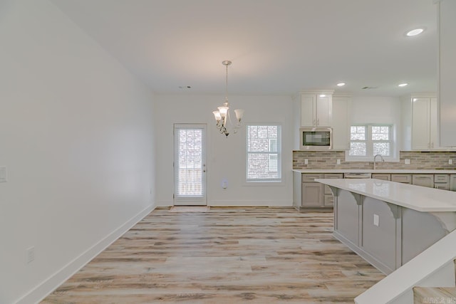 1500 S Church St, Jonesboro, AR 72401 - kitchen featuring stainless steel microwave, plenty of natural light, light countertops, tasteful backsplash, and recessed lighting