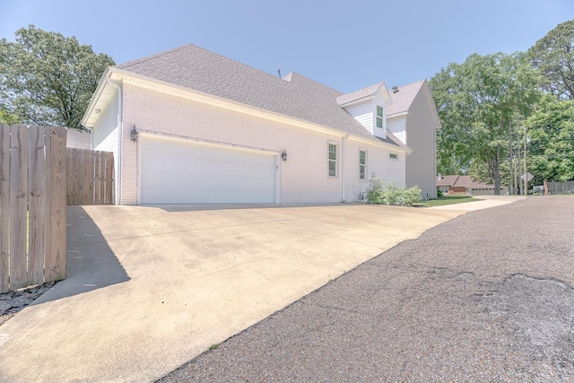 1500 S Church St, Jonesboro, AR 72401 - view of home's exterior featuring brick siding, a garage, concrete driveway, and a shingled roof