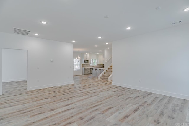 1500 S Church St, Jonesboro, AR 72401 - unfurnished living room featuring light wood-style floors, stairs, a chandelier, recessed lighting, and baseboards