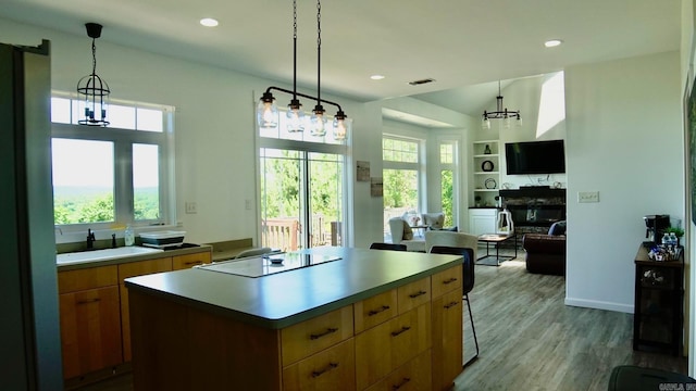 157 E Hawkview Pl, Royal, AR 71968 - kitchen featuring black electric cooktop, a sink, a chandelier, a kitchen island, and a glass covered fireplace