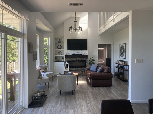 157 E Hawkview Pl, Royal, AR 71968 - living area featuring wood finished floors, a chandelier, a stone fireplace, high vaulted ceiling, and baseboards