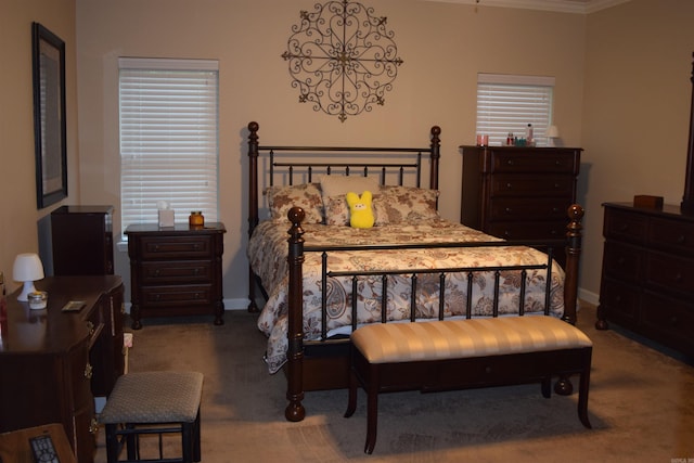 carpeted bedroom featuring crown molding and baseboards