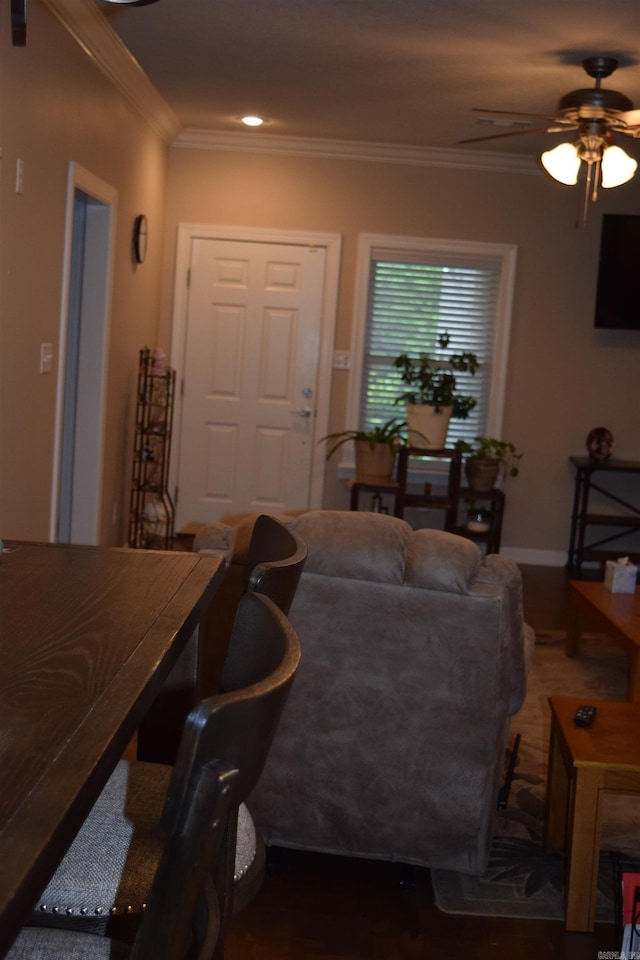 living area with a ceiling fan, crown molding, and wood finished floors