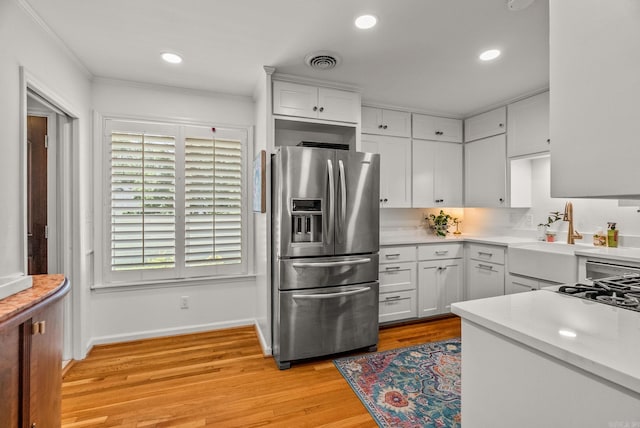 5412 S Grandview St, Little Rock, AR 72207 - kitchen featuring stainless steel fridge, a sink, baseboards, light countertops, and white cabinetry