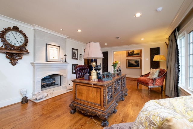 5313 N Grandview St, Little Rock, AR 72207 - living room featuring crown molding, light wood-style flooring, recessed lighting, a fireplace with raised hearth, and baseboards