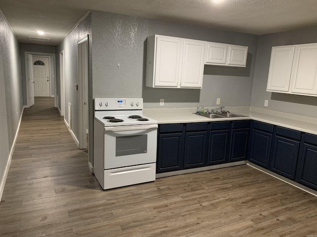 442 S Thornton, Piggott, AR 72454 - kitchen with electric range, a textured wall, light wood-style floors, a sink, and white cabinets