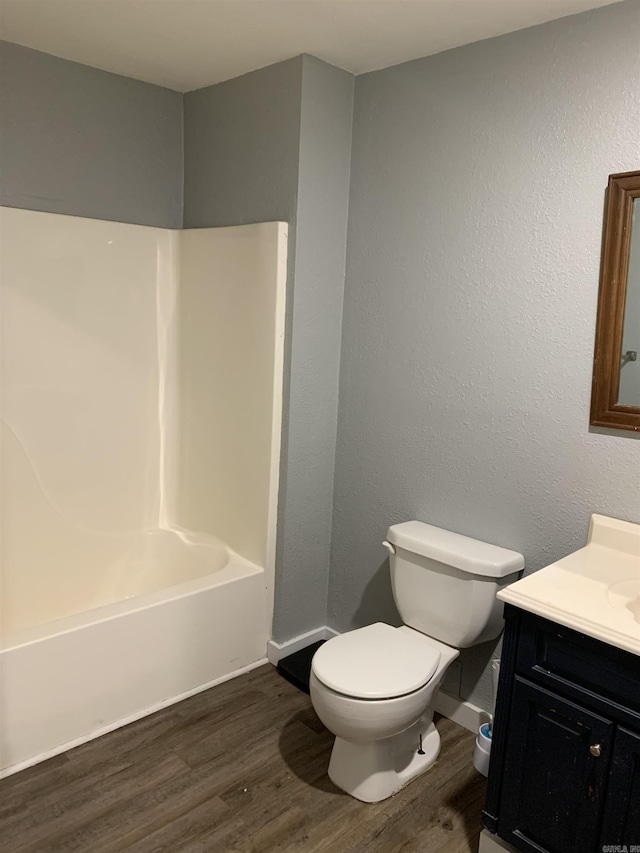 442 S Thornton, Piggott, AR 72454 - full bathroom with vanity, wood finished floors, toilet, baseboards, and washtub / shower combination