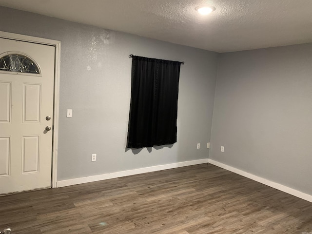 442 S Thornton, Piggott, AR 72454 - foyer entrance featuring dark wood finished floors, a textured ceiling, and baseboards
