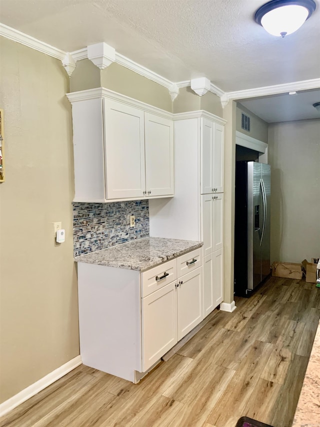 5405 Dreher Ln, Little Rock, AR 72209 - kitchen featuring stainless steel refrigerator with ice dispenser, light wood finished floors, white cabinets, tasteful backsplash, and a textured ceiling