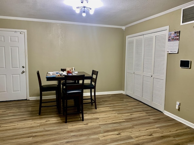 5405 Dreher Ln, Little Rock, AR 72209 - dining space featuring wood finished floors, a textured ceiling, ornamental molding, and baseboards
