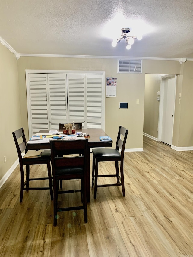 5405 Dreher Ln, Little Rock, AR 72209 - dining area featuring crown molding, a textured ceiling, light wood finished floors, and baseboards