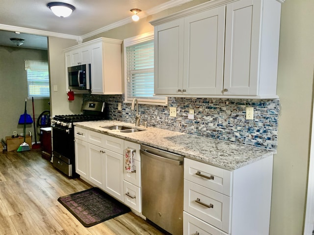 5405 Dreher Ln, Little Rock, AR 72209 - kitchen with appliances with stainless steel finishes, a sink, light wood-type flooring, crown molding, and decorative backsplash
