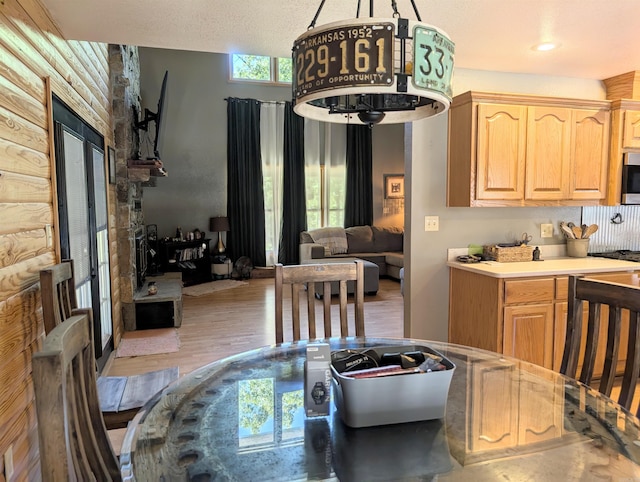 149 Polk Rd Unit 714, Mena, AR 71953 - kitchen featuring light brown cabinetry, wood finished floors, light countertops, stainless steel microwave, and open floor plan