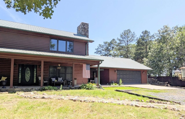 149 Polk Rd Unit 714, Mena, AR 71953 - view of front facade featuring a porch, metal roof, concrete driveway, a chimney, and a garage