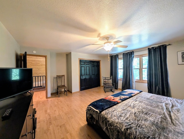149 Polk Rd Unit 714, Mena, AR 71953 - bedroom featuring light wood-type flooring, a textured ceiling, ceiling fan, a closet, and baseboards