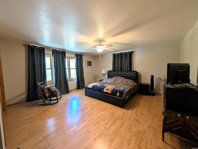149 Polk Rd Unit 714, Mena, AR 71953 - bedroom featuring light wood-style floors, a textured ceiling, ceiling fan, and baseboards