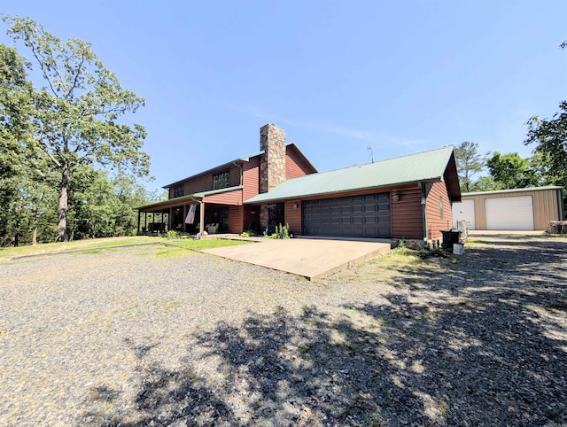 149 Polk Rd Unit 714, Mena, AR 71953 - view of side of property featuring a garage and a chimney