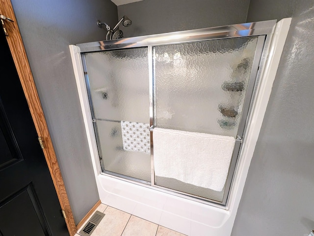 149 Polk Rd Unit 714, Mena, AR 71953 - bathroom with tile patterned flooring, shower / bath combination with glass door, and a textured wall