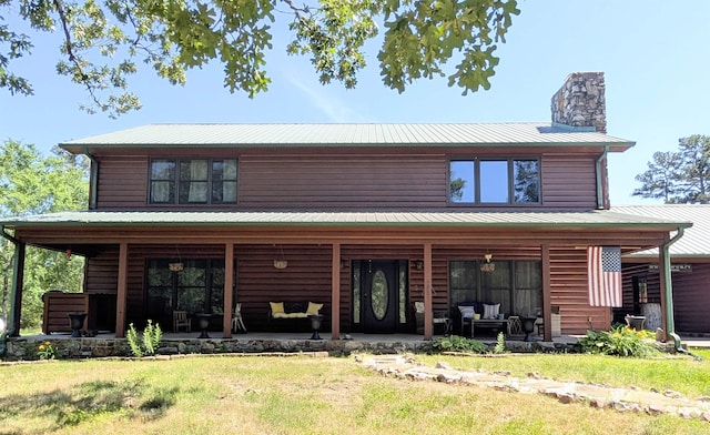 149 Polk Rd Unit 714, Mena, AR 71953 - view of front facade featuring a chimney, metal roof, a porch, and a front lawn