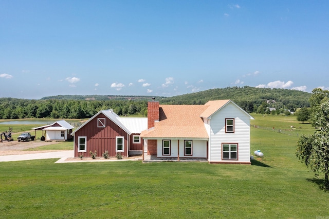 410 Rocky Point Rd, Vilonia, AR 72173 - view of front facade with board and batten siding, a chimney, a front lawn, and a wooded view