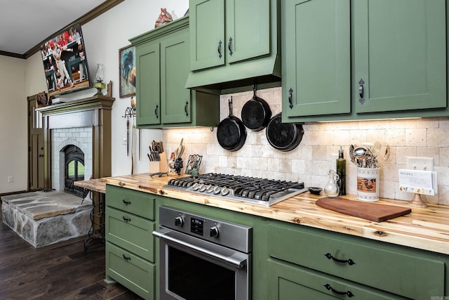 410 Rocky Point Rd, Vilonia, AR 72173 - kitchen with wood counters, appliances with stainless steel finishes, green cabinetry, crown molding, and dark wood-style flooring