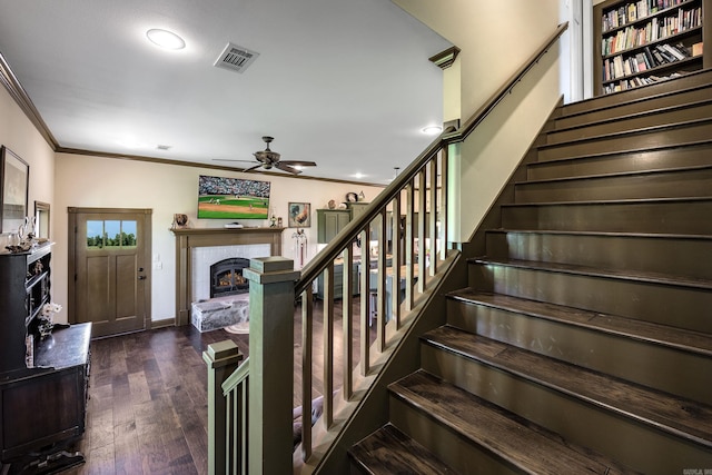 410 Rocky Point Rd, Vilonia, AR 72173 - stairway featuring a lit fireplace, ceiling fan, wood finished floors, ornamental molding, and recessed lighting