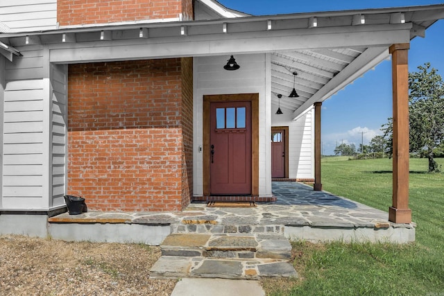 410 Rocky Point Rd, Vilonia, AR 72173 - view of exterior entry featuring brick siding and a lawn