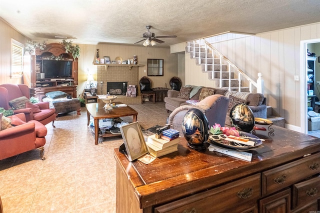815 Meadowbrook Ln S, Wynne, AR 72396 - tiled living area featuring a ceiling fan, stairway, a fireplace, and a textured ceiling