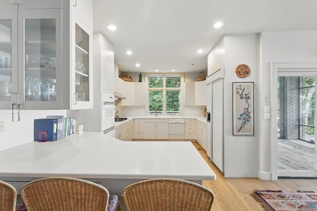 8 River View Pt, Little Rock, AR 72227 - kitchen with light wood-style flooring, a peninsula, plenty of natural light, under cabinet range hood, and recessed lighting