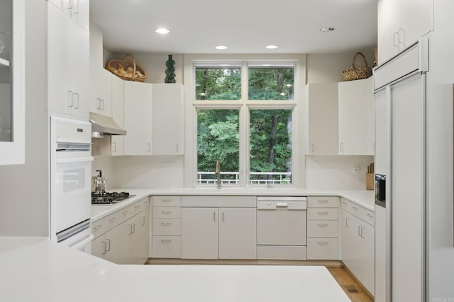 8 River View Pt, Little Rock, AR 72227 - kitchen featuring white appliances, under cabinet range hood, light countertops, tasteful backsplash, and a sink