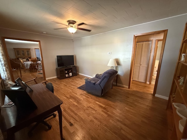 221 N Garfield Ave, Piggott, AR 72454 - living room with a ceiling fan, wood finished floors, and baseboards