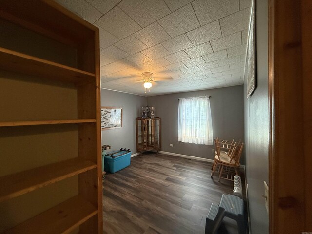 221 N Garfield Ave, Piggott, AR 72454 - living area with a ceiling fan, dark wood-style flooring, and baseboards
