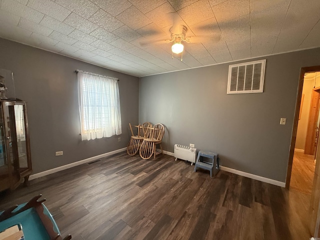 221 N Garfield Ave, Piggott, AR 72454 - unfurnished room with wood finished floors, ceiling fan, and baseboards
