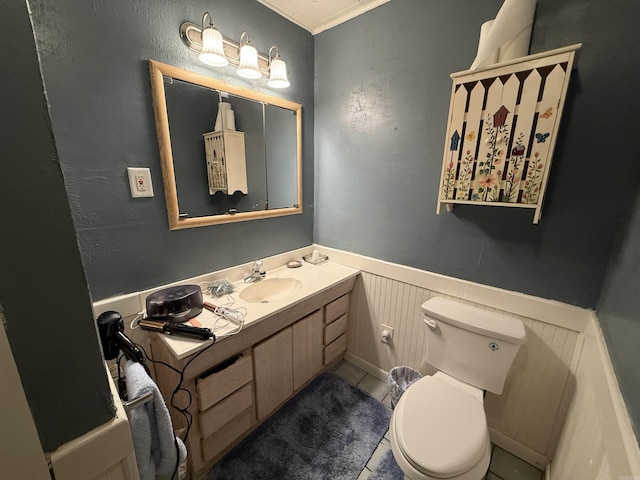 221 N Garfield Ave, Piggott, AR 72454 - bathroom with toilet, wainscoting, vanity, a decorative wall, and crown molding