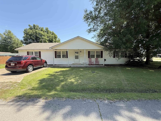 221 N Garfield Ave, Piggott, AR 72454 - ranch-style home featuring a front lawn, a porch, and concrete driveway