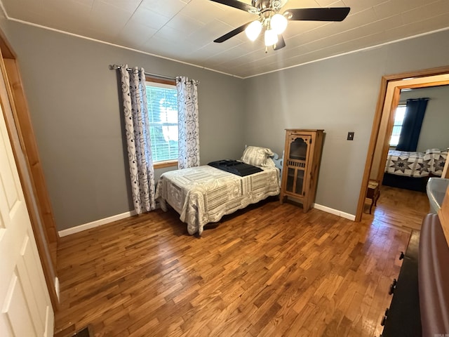 221 N Garfield Ave, Piggott, AR 72454 - bedroom featuring wood finished floors, baseboards, and ceiling fan