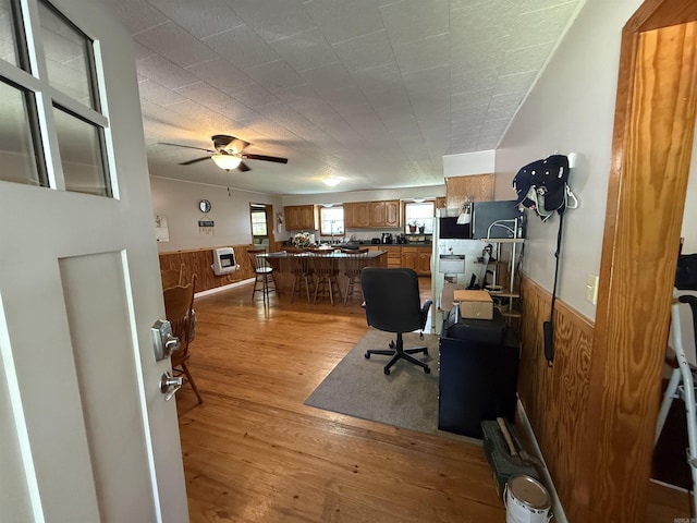 221 N Garfield Ave, Piggott, AR 72454 - office area featuring a wainscoted wall, wooden walls, light wood-style floors, a ceiling fan, and heating unit