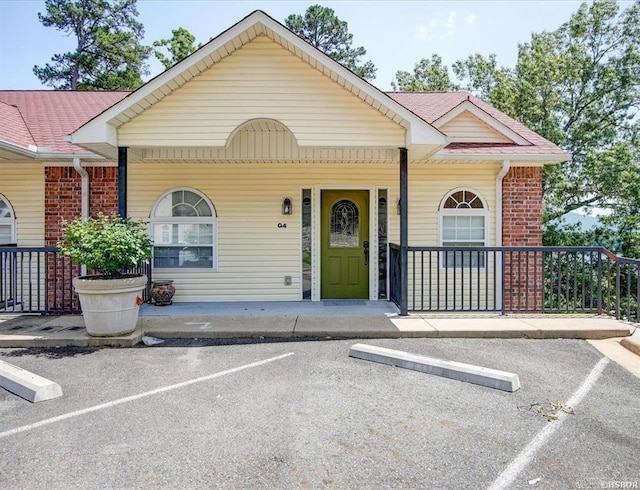 321 Peters Pt, Hot Springs, AR 71913 - view of front facade with uncovered parking, covered porch, brick siding, and roof with shingles
