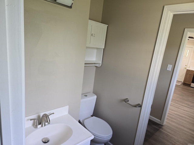 311 Ce Brawner Rd, Wynne, AR 72396 - bathroom featuring toilet, wood finished floors, baseboards, and vanity